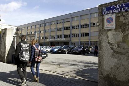 Dos j&oacute;venes pasan por delante del colegio Valdeluz.