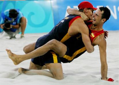 Javier Bosma (con gorra) y Pablo Herrera celebran su triunfo sobre los canadienses abrazándose sobre la arena.