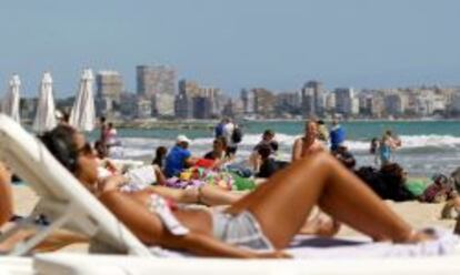 Centenares de turistas disfrutan del sol y las altas temperaturas en la playa del Postiguet de Alicante.