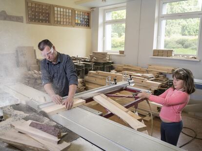 Eriks Oficier (43) y Renate (8), en la carpintería familiar en Kuldiga, Letonia, donde la hija ayuda y experimenta con su padre.
