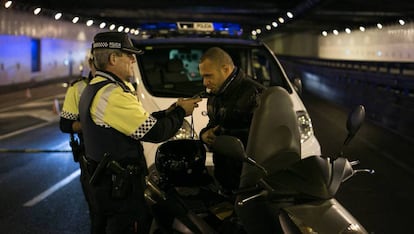 Un agente de la Guardia Urbana de Barcelona hace la prueba de alcoholemia a un motorista.