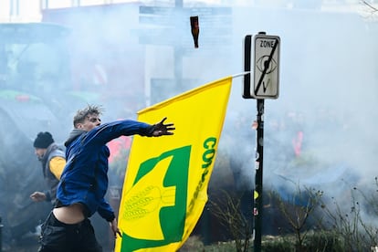 Un manifestante lanza una botella a la policía durante la protesta de agricultores, este jueves en Bruselas.