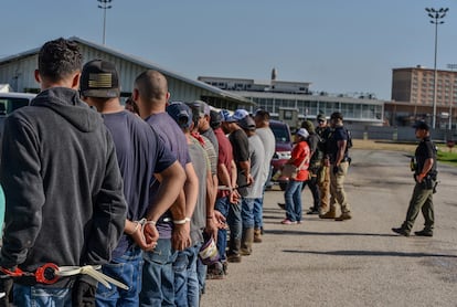 Migrantes detenidos por elementos del ICE, durante un operativo en un hipódromo en Luisiana, el 18 de junio.