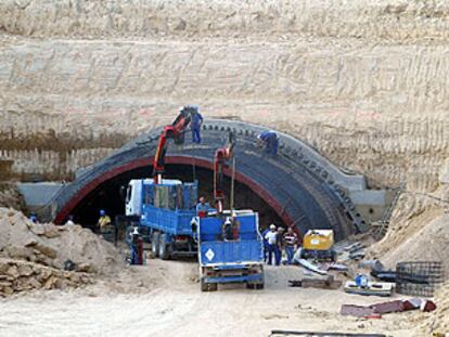 Un grupo de operarios trabaja en la entrada al túnel bajo el parque de Juan Carlos I.
