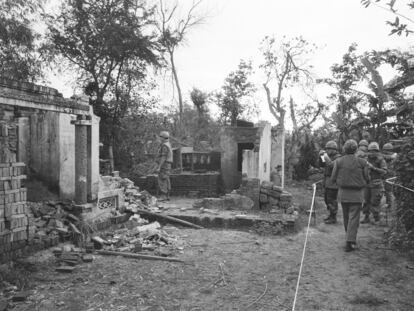 American soldiers look over the remains of a home in My Lai