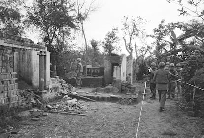 American soldiers look over the remains of a home in My Lai