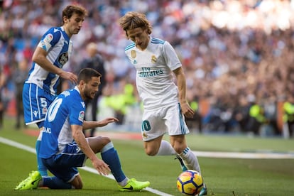 El centrocampista croata del Real Madrid, Luka Modric (d) con el balón ante el delantero rumano del Deportivo Florin Andone luchan por el balón.