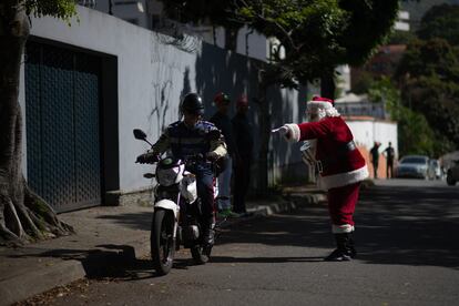 Uno de los Santa Claus voluntarios pide colaboraciones para el evento "Santa en las calles".