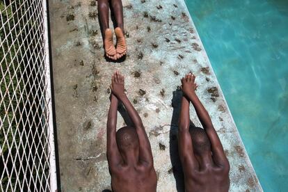 Niños ensayan su estilo de natación durante una clase en una piscina privada, en la zona de Port-au-Prince, Carrefour, Haití.