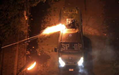 Policías antidisturbios lanzan gas lacrimógeno a los manifestantes.