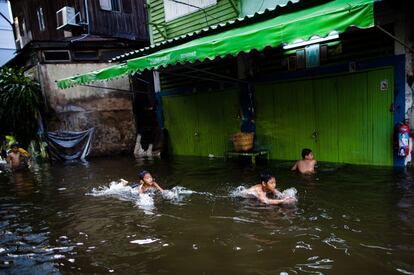 Unos niños juegan en una calle inundada en Bangkok