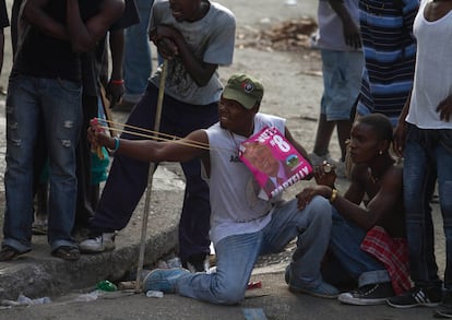 Un partidario del candidato presidencial, Michel Martelly, que se ha quedado fuera de la segunda vuelta de las presidenciales, lanza piedras contra cascos azules de la ONU.