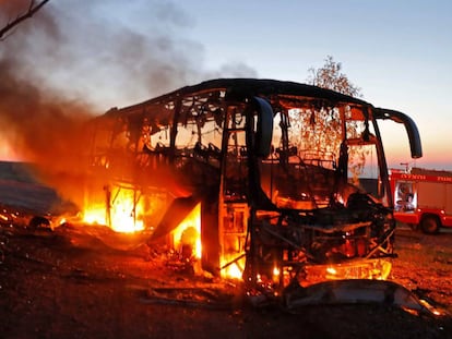 Um ônibus arde depois de ser alcançado por fogo palestino.