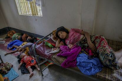 Una mujer rohingya, recién llegada al campo de refugiados de Kutupalong (Bangladés) descansa junto a sus hijos.
