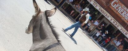 Un vaquero escenifica un tiroteo junto a un burro semisalvaje en Oatman (Arizona), por donde pasa la Ruta 66.