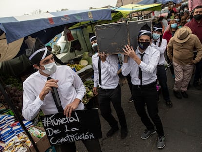 El candidato a la asamblea constituyente Daniel Andrade, a la izquierda, participa en una actuación callejera llamada 'Funeral de la Constitución' en referencia a la constitución de la era militar de Chile, mientras hace campaña en un mercado al aire libre en Santiago, Chile, el pasado sábado 8 de mayo de 2021.