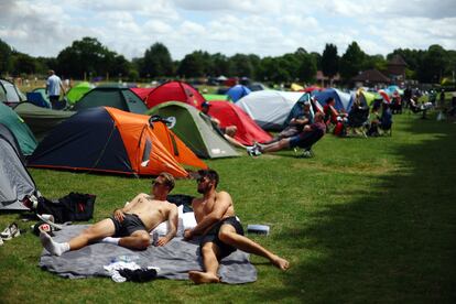 Dos aficionados descansan en la zona de acampada de Wimbledon.
