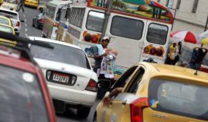 Vendedores ambulantes caminan en medio del tránsito vehicular en el centro histórico de Ciudad de Panamá, donde se llevará a cabo la XXIII Cumbre Iberoamericana.