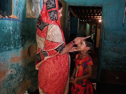 La madre de Priyambada Rana, de siete años, prepara a su hija antes de salir de camino a su escuela en Cuttack, en el estado de Orissa, India.