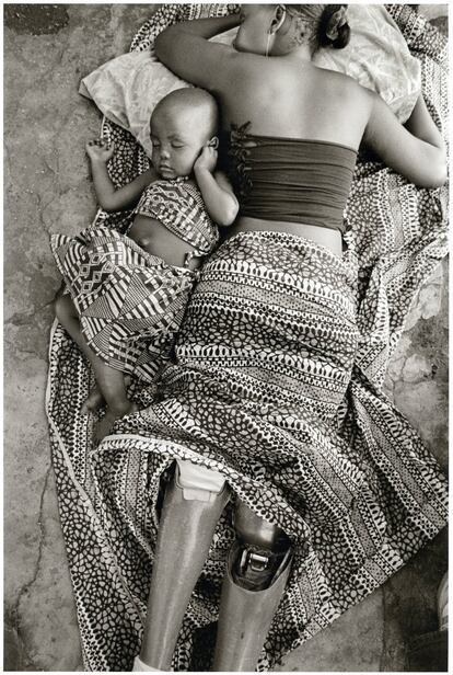 Una joven mozambiqueña que perdió las piernas por culpa de la minas antipersona, duerme junto a su hijo. Foto ganadora del Premio Ortega y Gasset en 2008.