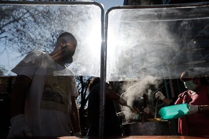 Un grupo de voluntarios reparte comida frente a la parroquia Santa María Madre del Pueblo, en Buenos Aires (Argentina).