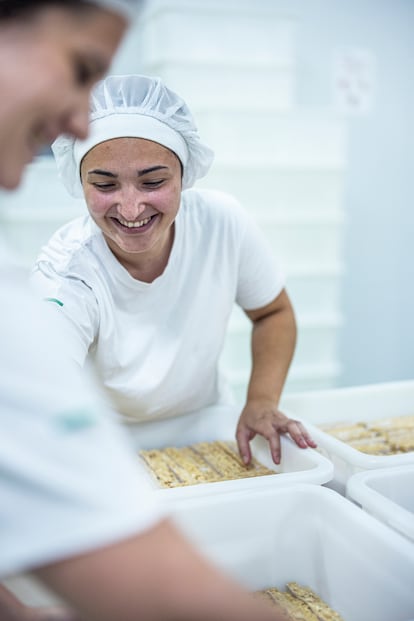 Una trabajadora pone el turrón a enfriar en bandejas.