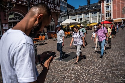 Manzuri revisa el mapa de su teléfono ante el paso de un grupo de turistas alemanes por el centro de Fulda. La integración dentro de la comunidad europea es extremadamente difícil para las personas afganas, con una sociedad y una cultura completamente diferentes, lamenta el propio Manzuri. 