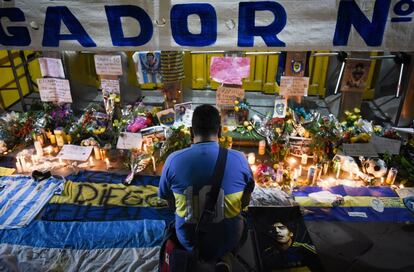 Un hombre junto a un altar improvisado tras la muerte de Diego Maradona en el exterior del estadio Alberto J. Armando, La Bombonera, en Buenos Aires.
