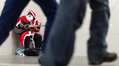 Un hombre disfrazado de Papá Noel toca la guitarra en el metro de Berlín (Alemania), el 14 de diciembre de 2016.