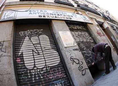 Un trabajador del Centro Joven de Anticoncepción y Sexualidad, en la calle de San Vicente Ferrer, echa el cierre al acabar la jornada.