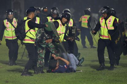 Mahfud MD, ministro coordinador de asuntos de Seguridad, ha difundido algunas irregularidades en la celebración del encuentro, como la venta de 42.000 entradas, cuando el estadio solo tiene capacidad para 38.000 personas. En la imagen, agentes de seguridad detienen a un joven dentro del estadio.