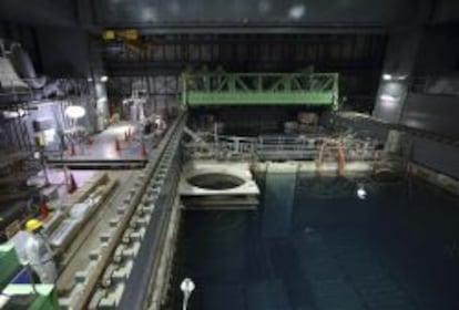 Un empleado de Tokyo Electric Power (TEPCO) se protege con un traje y una m&aacute;scara mientras trabaja en la piscina del reactor 4 en la central nuclear de Fukushima.