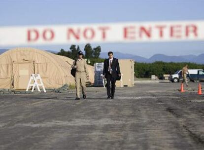 Miembros del equipo de abogados defensores caminan por el terreno asignado para el tribunal en la base de Guantánamo.