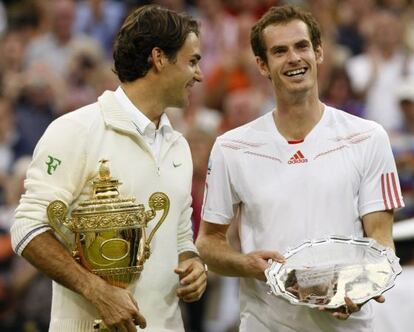 Federer sostiene la copa de campeón juanto a Murray