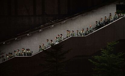 Miles de personas siguen concentradas en el centro de Hong Kong para pedir la elección democrática del Ejecutivo de la ciudad, tras otra noche de tensión y uso de gases lacrimógenos por parte de la policía. En la imagen, agentes de seguridad se movilizan, el 29 de septiembre de 2014.