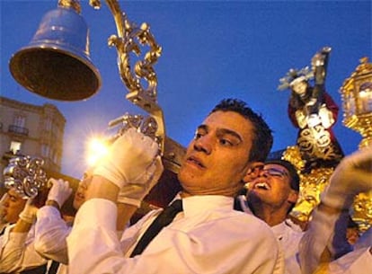 Los costaleros de la cofradía de Nuestro Padre Jesus Nazareno mantienen a pulso el paso en el encuentro con el de la Virgen de la Amargura, durante la procesión de ambas cofradías por las calles de Almería.