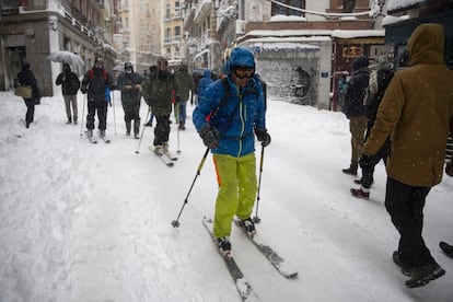 Varios jóvenes se deslizan con esquís por la calle Postas de Madrid, este sábado.