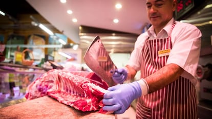 Un carnicero prepara un pedido en un supermercado en Santiago de Compostela.