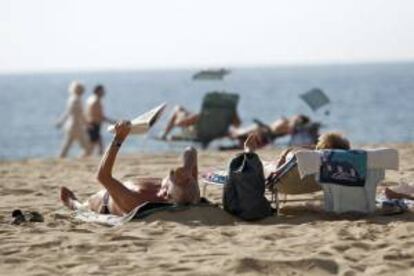 Unos turistas toman el sol en la playa de Levante de Benidorm. EFE/Archivo