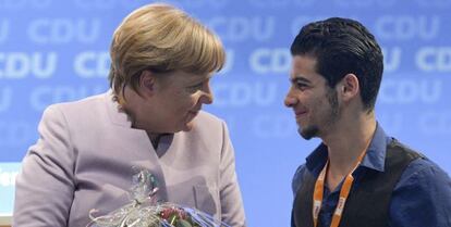 La canciller alemana, Angela Merkel agradece al refugiado sirio Mohammad Hussan su discurso durante una conferencia regional de la CDU.