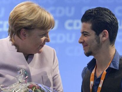 La canciller alemana, Angela Merkel agradece al refugiado sirio Mohammad Hussan su discurso durante una conferencia regional de la CDU.