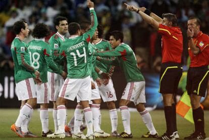 El árbitro Rosetti, junto al linier Ayroldi, da por válido el gol ilegal de Tévez ante las protestas mexicanas.