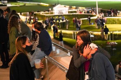 Tres jóvenes charlan en el Hipódromo de la Zarzuela.