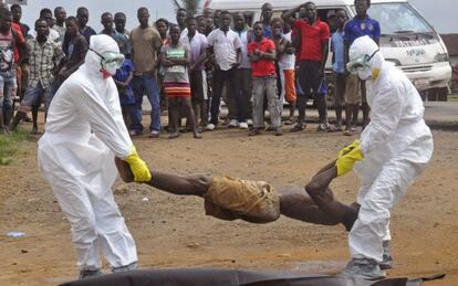 Los equipos sanitarios retiran, en Monrovia, el cuerpo de un hombre sospechoso de &eacute;bola.