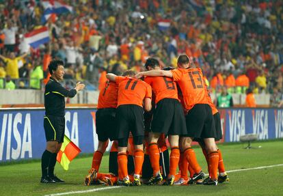 Los jugadores holandes celebran el gol de Sneijder, ante la presencia, sonriente, del juez de línea.