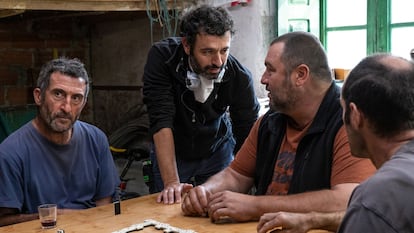 Rodrigo Sorogoyen, de pie, entre Luis Zahera (izquierda) y Denis Ménochet, en el rodaje de 'As bestas'.