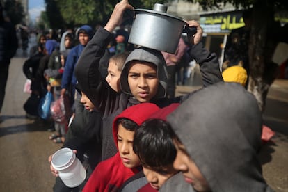 Niños palestinos desplazados hacen fila para recibir comida en un campo de refugiados en Gaza, en febrero de 2024.