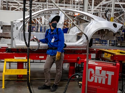 Un empleado vigila la producción en una fábrica de coches.