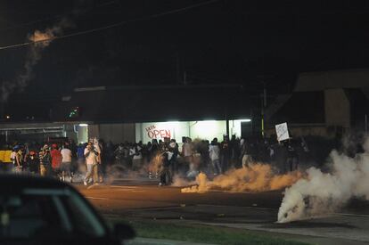 Los manifestantes huyen del gas lacrimógeno lanzado por la policía.