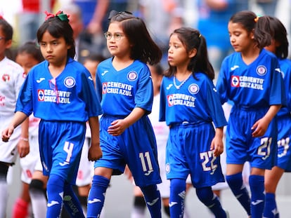 Niñas con el uniforme del Cruz Azul entran al campo antes de un partido de la Liga MX, en 2020.